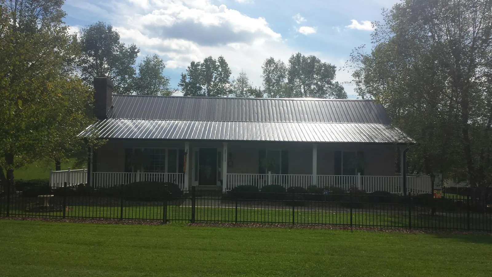 Gray metal roof on a brick ranch with a full width front porch — Gutter Guard Installation work by our crew in Fielding
